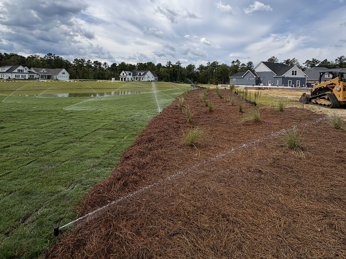 JP Landscapes crew running irrigation on a new sod lawn