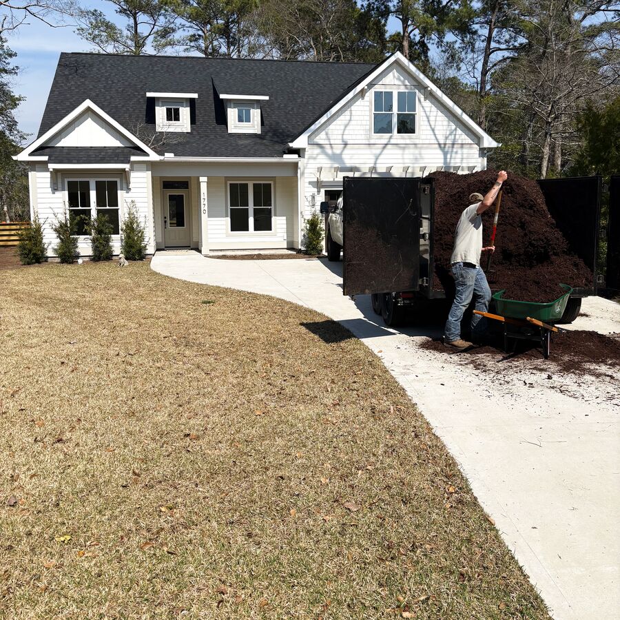 Jesse Prince installing fresh mulch at a client home