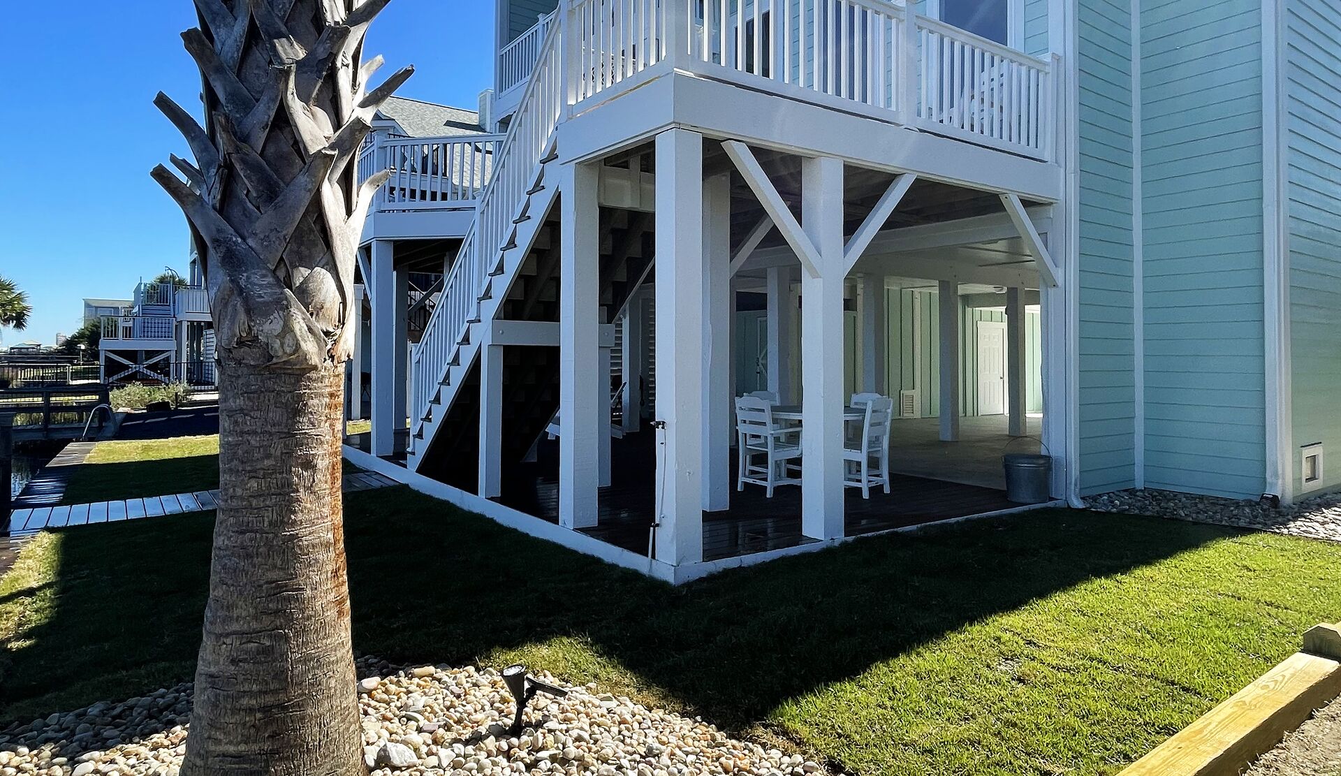 Coastal home with fresh sod, palm and rock beds