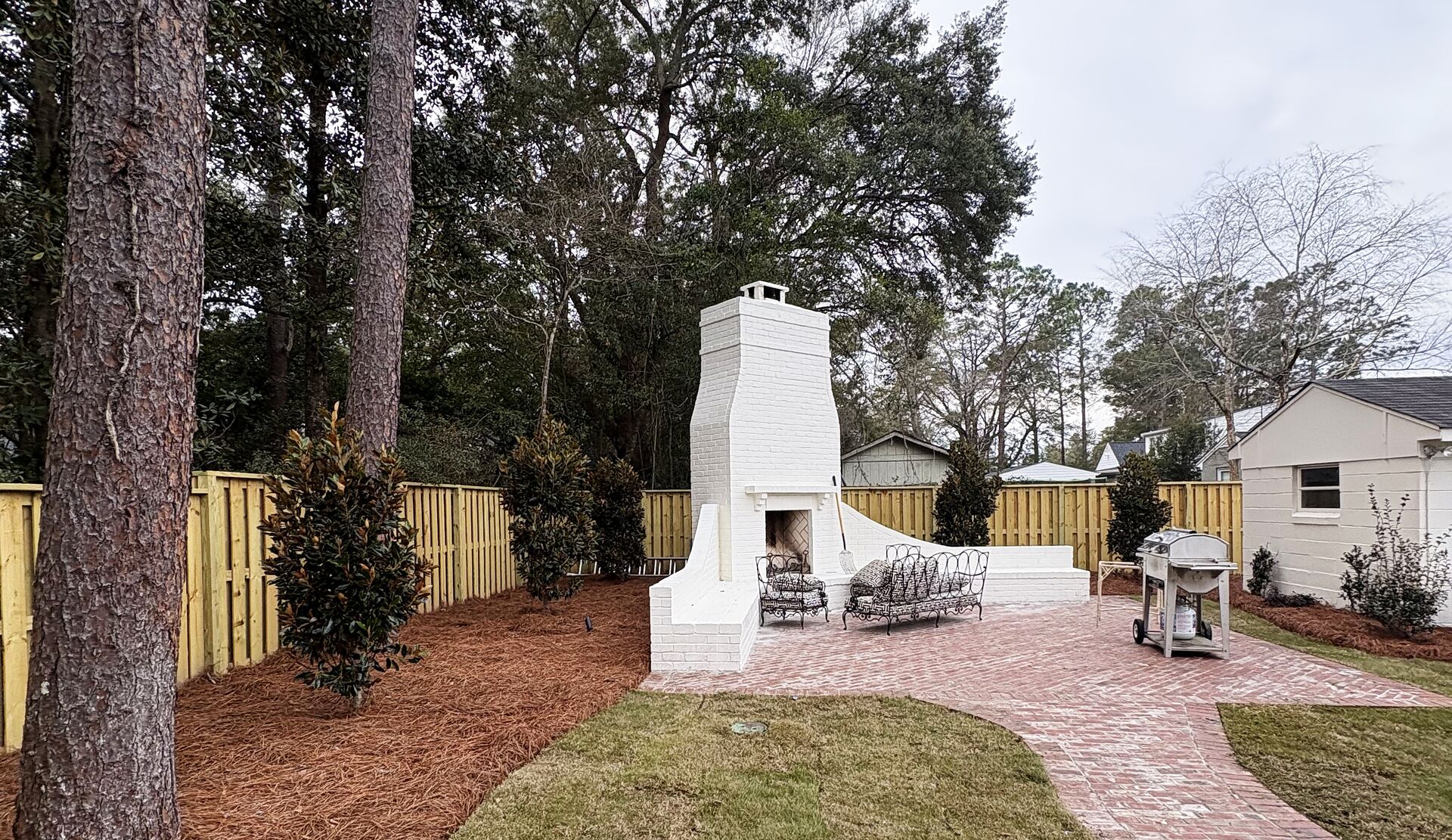 Renovated backyard with outdoor fireplace and paver patio